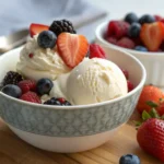 Tart yogurt ice cream topped with fresh berries in a bowl