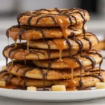 caramel apple pretzel bites stacked with caramel and chocolate drizzle